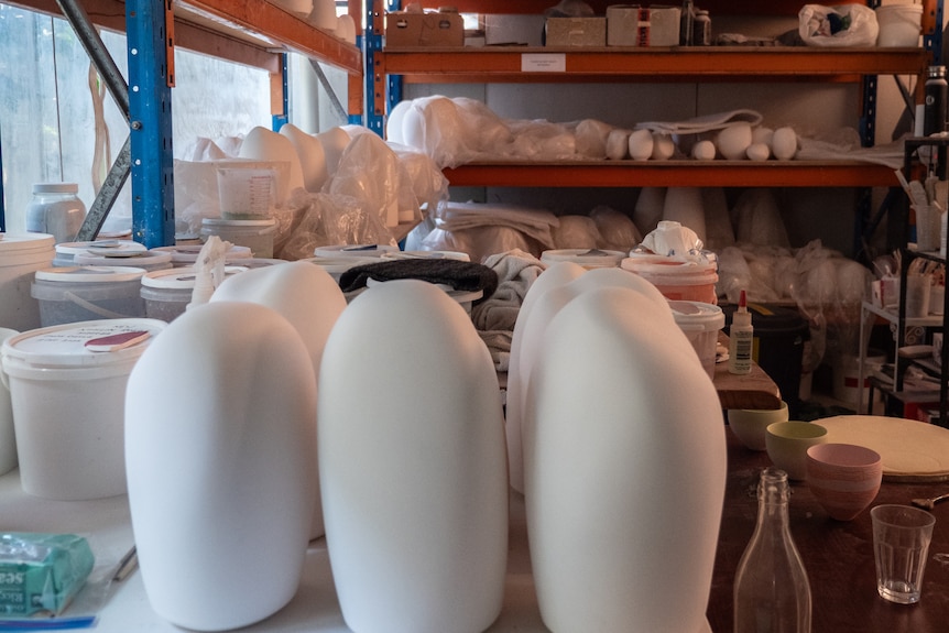 Pottery studio with tall, white pieces awaiting completion