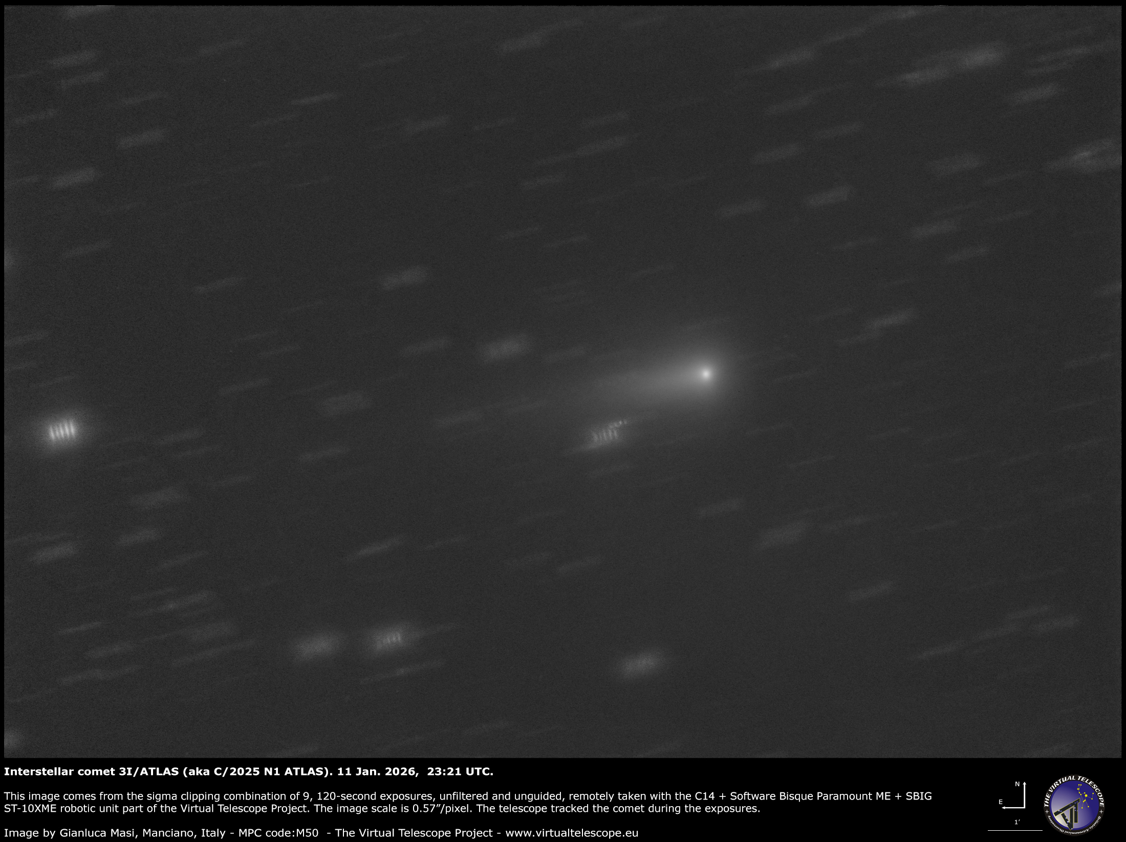 A comet is pictured as a bright point of light surrounded by a diffuse glow and tail trailing off to the left among the blurred lights of the starfield beyond.