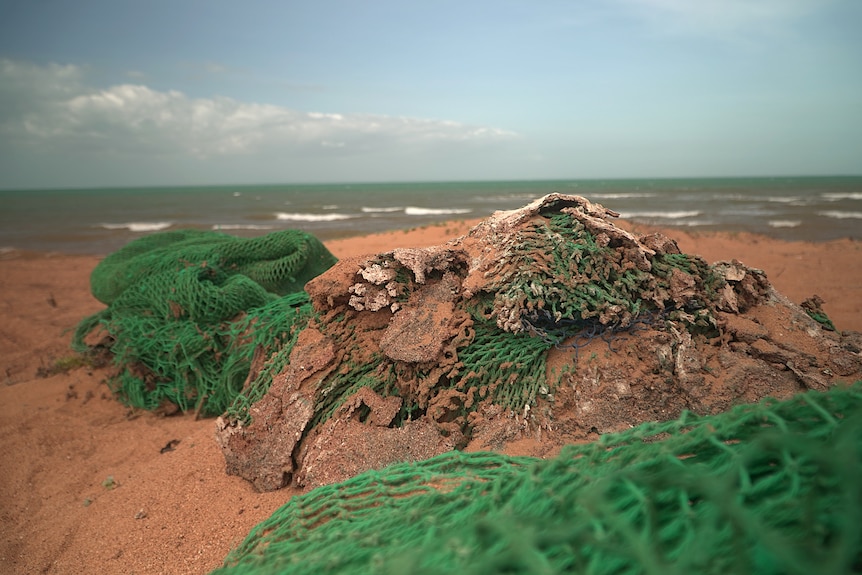 A large pile of nets on the beach.