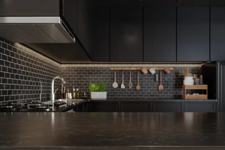 Modern kitchen with dark cabinets, tiled backsplash, stainless steel appliances, a potted plant, and utensils hanging on the wall