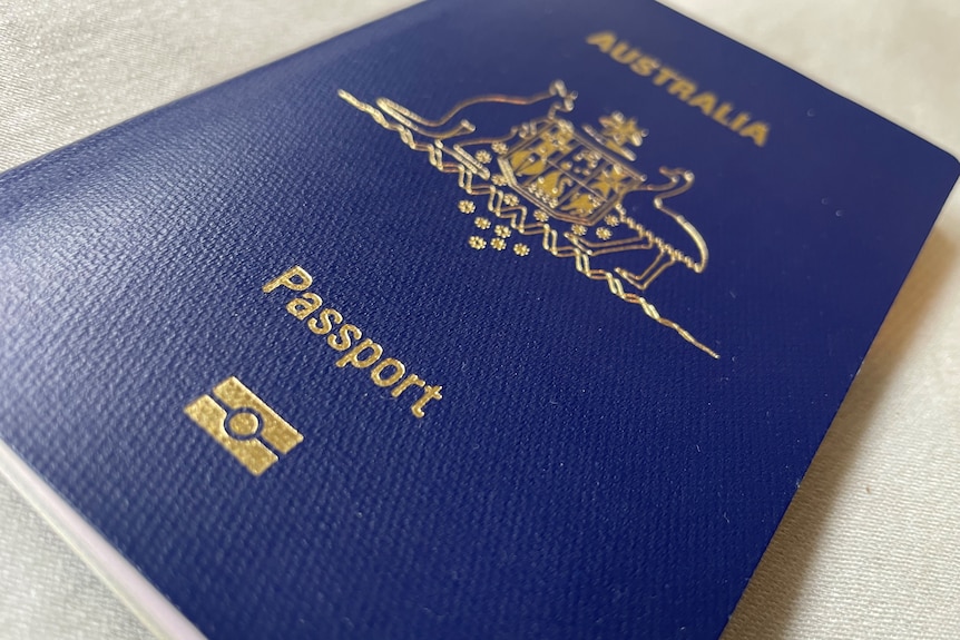 The cover over an Australian passport with gold embossed writing and a navy blue cover