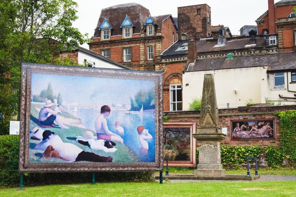 a large painting in an ornate frame on display in a park in stoke on trent