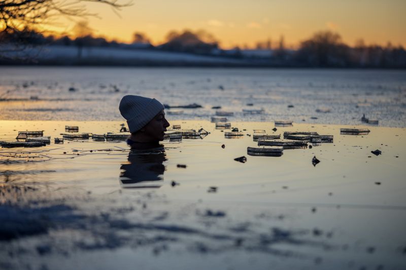 Cold water swimmer Autumn Lea takes a freezing dip at sunset in the icy waters of Pickmere Lake. (Photo: Christopher Furlong/Gettty Images)