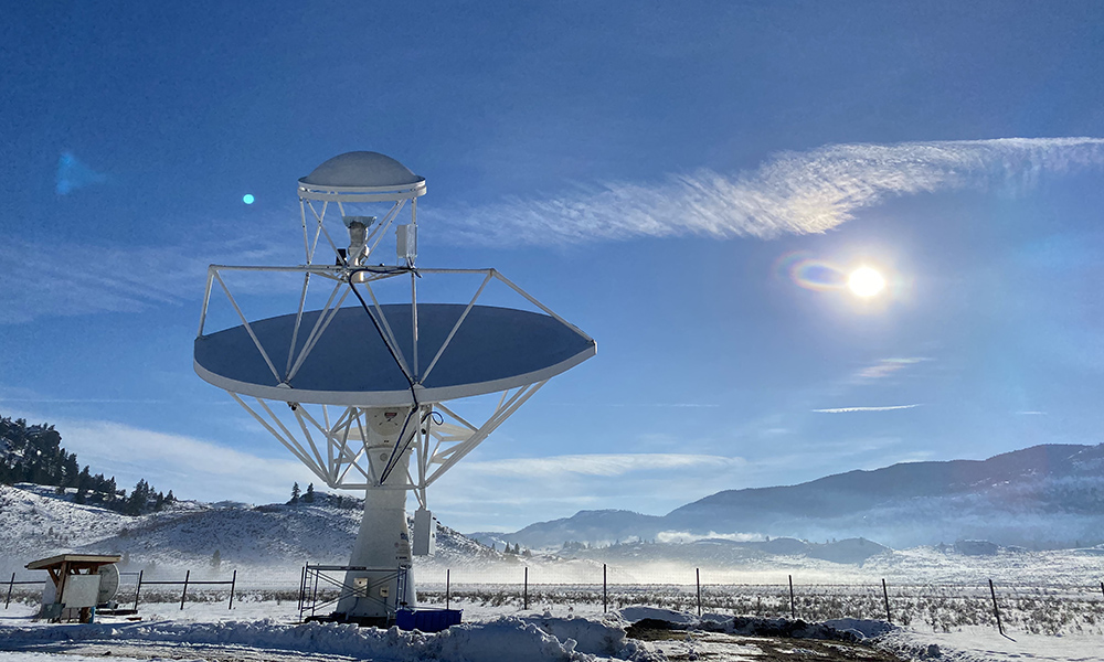 Radio telescope is shown against a cold winter sky.