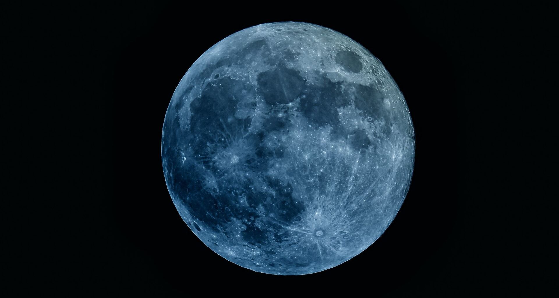 Image of a full moon with a blue hue for artistic effect. The moon doesn't turn blue during a "Blue Moon".
