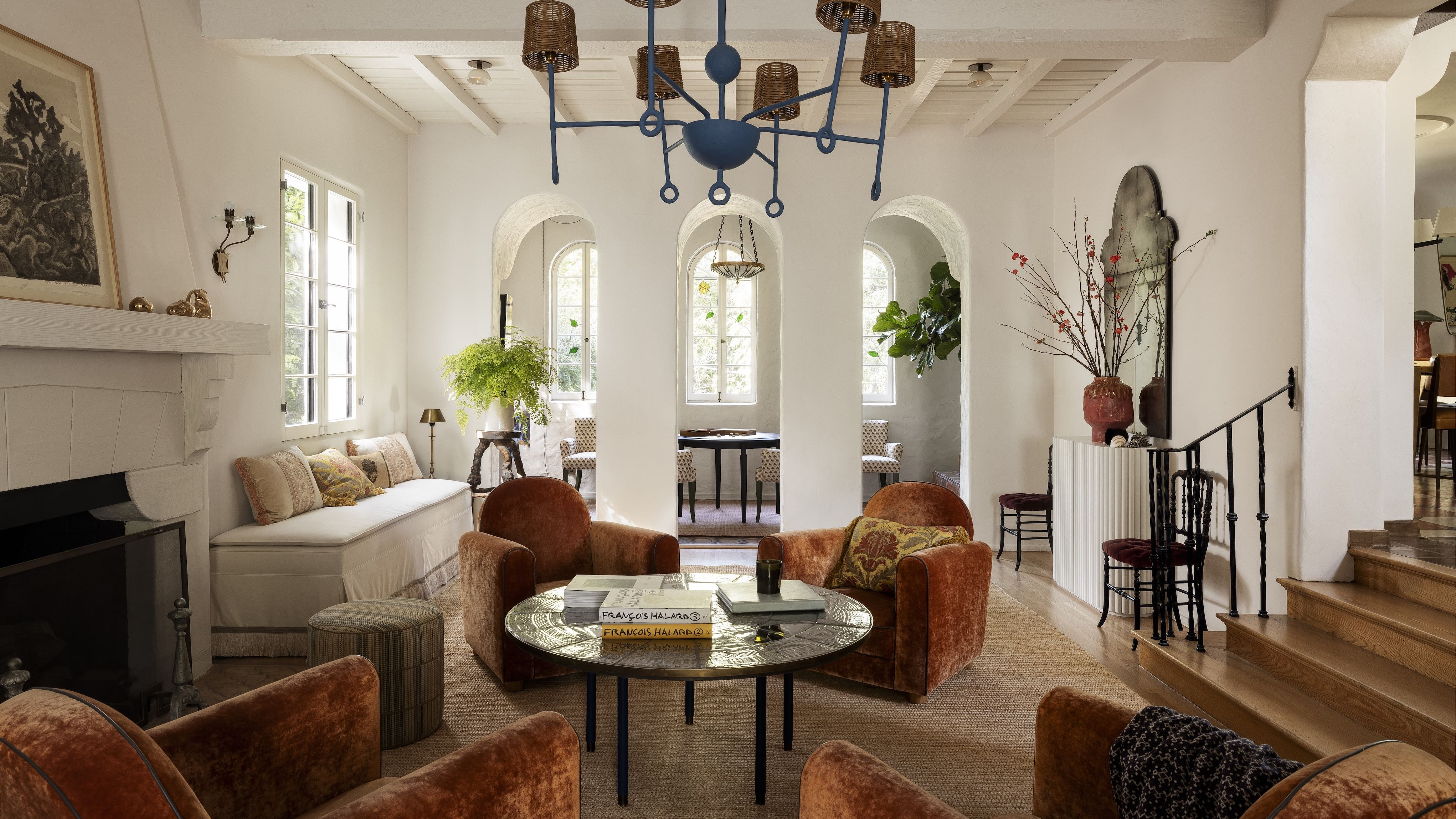 A living room in California's Los Feliz neighborwood, complete with arched openings on one end and a cluster of club chairs in the center.