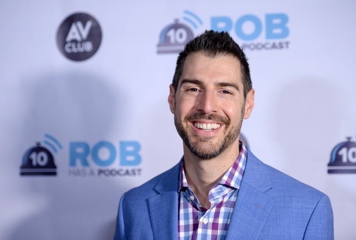 Rob Cesternino smiles ahead wearing a powder blue suit.