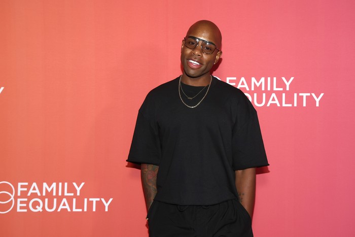 Monét X Change stood looking ahead wearing all black with their hands tucking into their pockets.