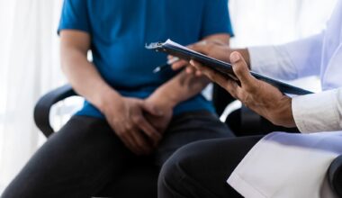 Male patient sitting in doctors office. Man hands holding crotch area