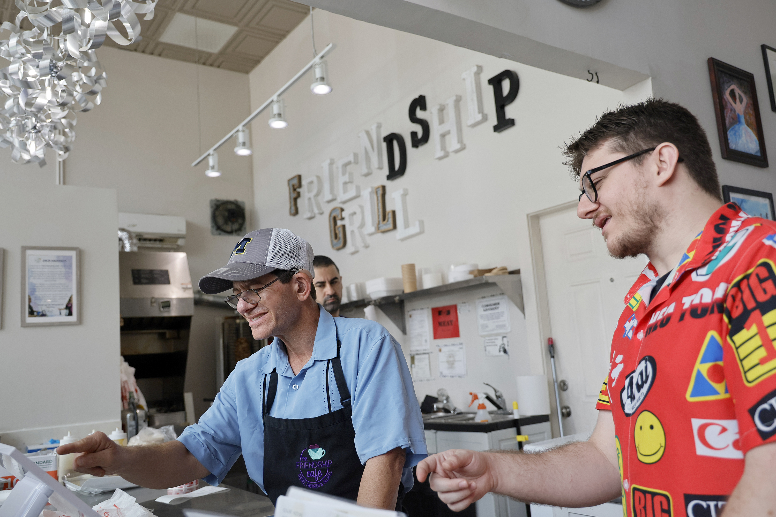Assistant teacher Josh Stedner, right, trains Randy Kugler to use...