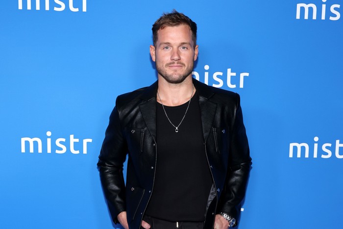 Colton Underwood looking ahead whilst wearing all black and standing with his hands in his pockets.