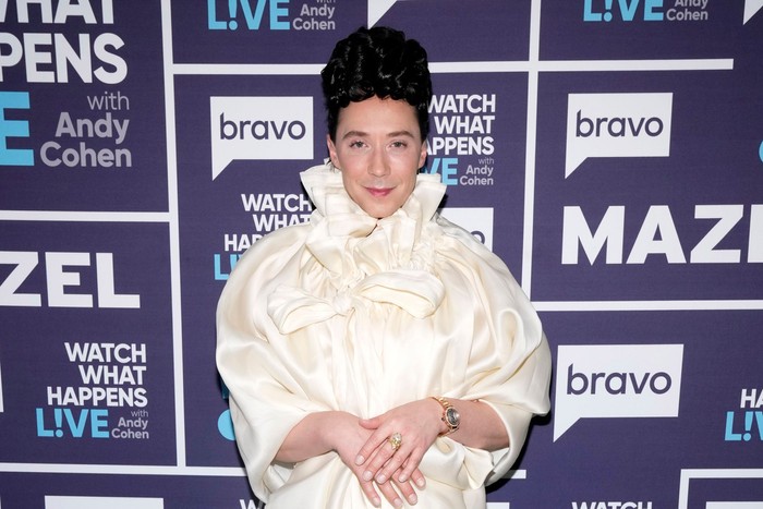 Johnny Weir stood with hands clasped in front of him and smiling ahead.