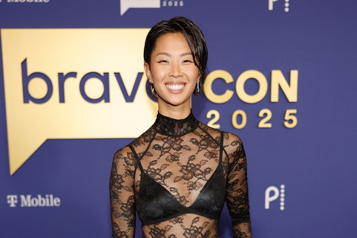 Kristen Kish stood wearing a black lace top and smiling ahead.