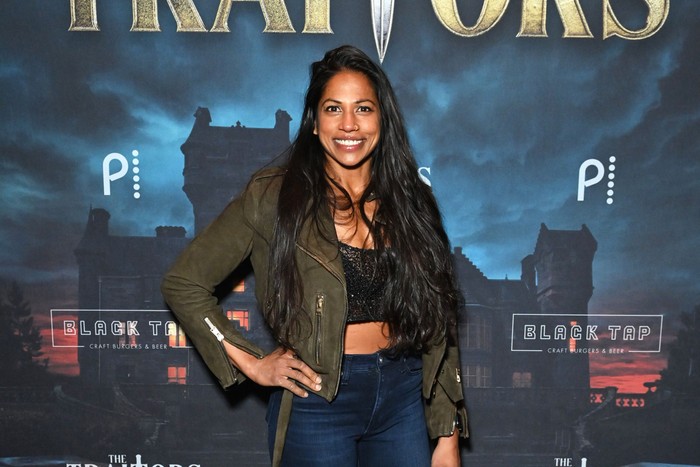 Natalie Anderson smiles ahead with one hand on her hip.