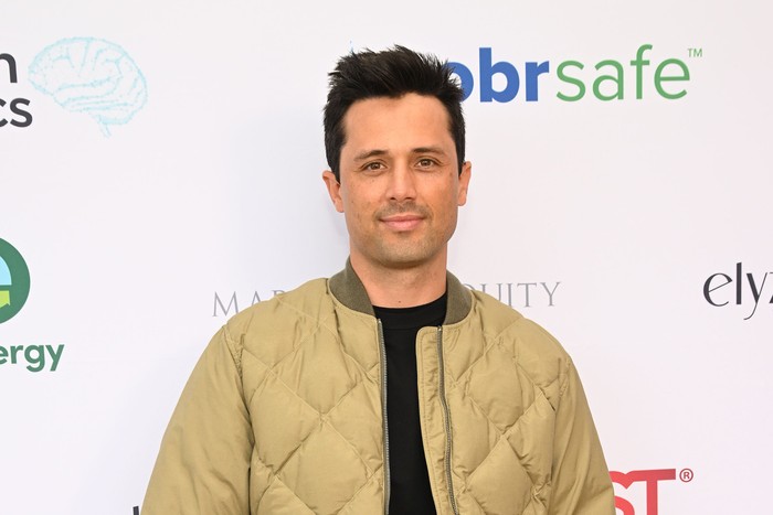 Stephen Colletti wearing a beige quilted jacket and smiling ahead.
