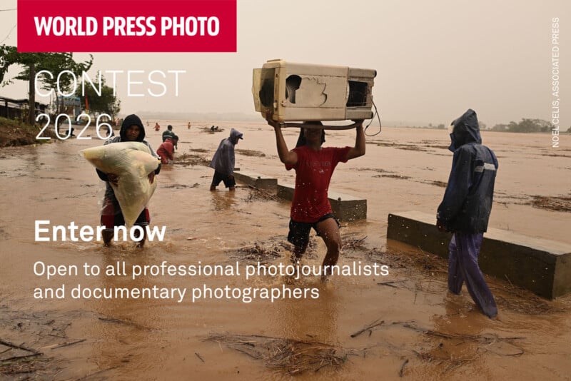 People wade through floodwaters, one carrying a microwave on his head and another holding a large bag, as rain falls. Text invites photojournalists to enter the World Press Photo Contest 2026.
