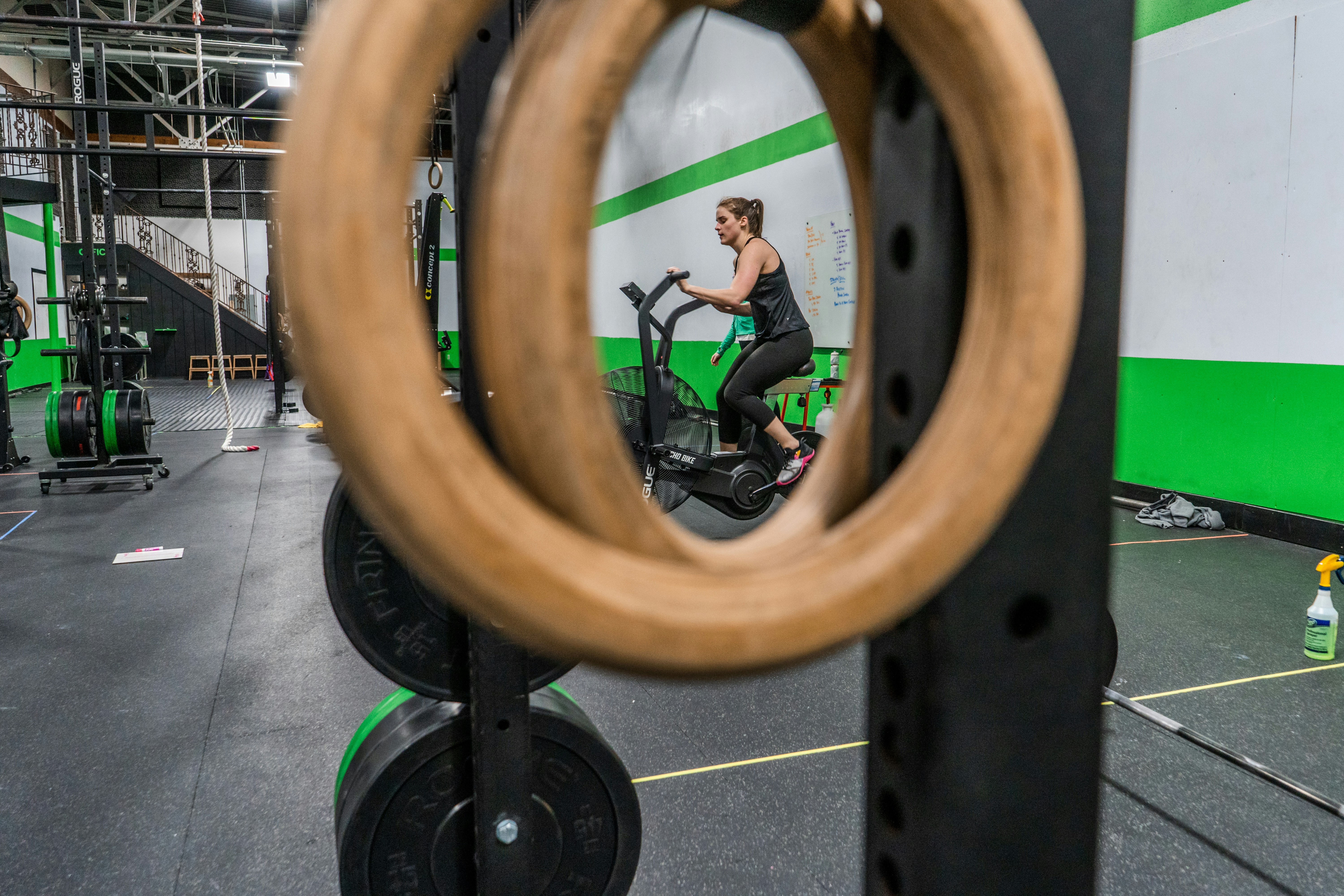 Woman on stationary bike as seen through gym quipment