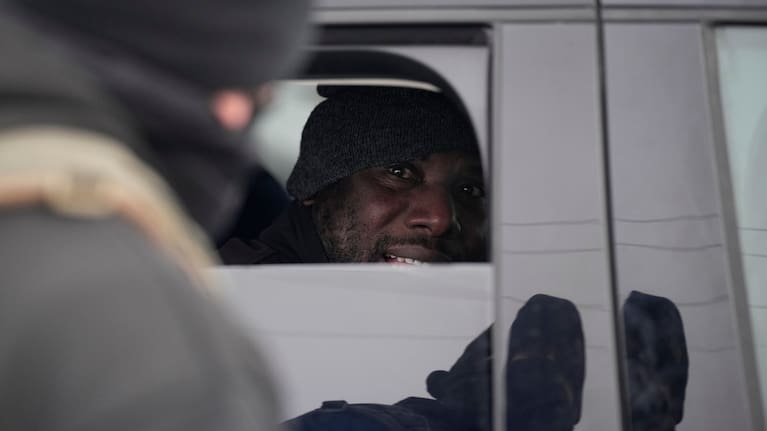 A man looks out of a car window after being detained by Immigration and Customs Enforcement (ICE) agents during a traffic stop.