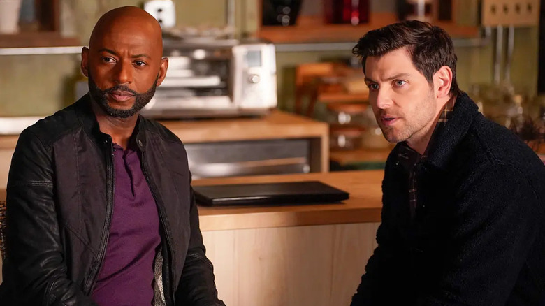 Rome Howard & Eddie Saville look intently at something in a cafe in A Million Little Things