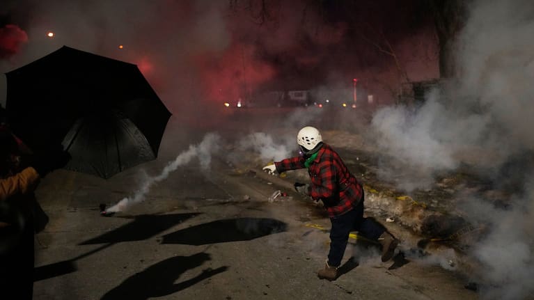 A protester throws back a tear gas canister during a protest after a shooting on Wednesday, January 14, 2026, in Minneapolis.