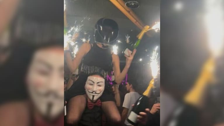 A waitress holds Champagne bottles topped with sparklers moments before a fatal fire at a Swiss ski resort bar.