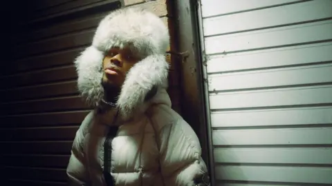 Igoris Tarran Jim Legxacy in a white padded coat