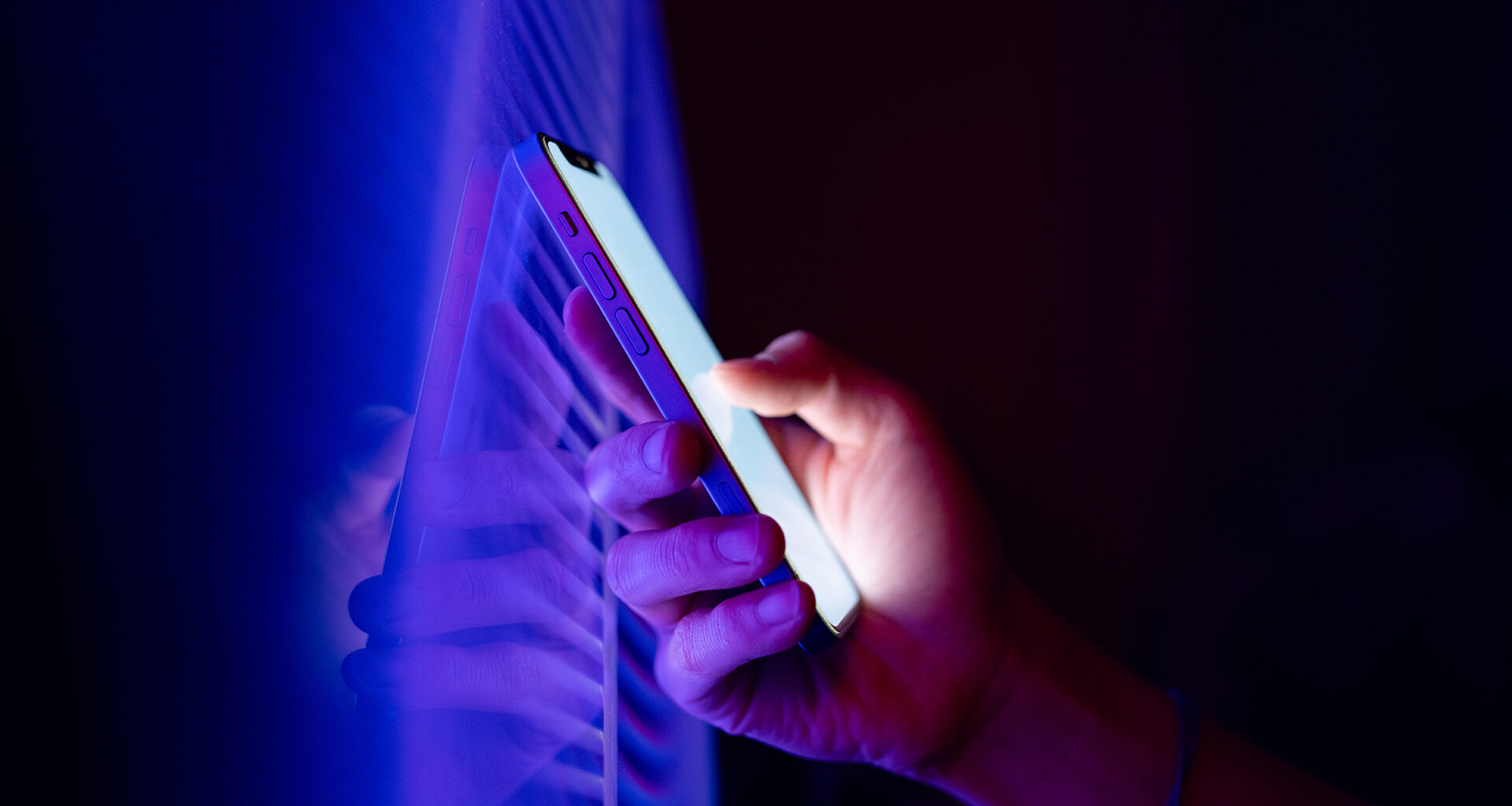 Person holding a smartphone in the dark.