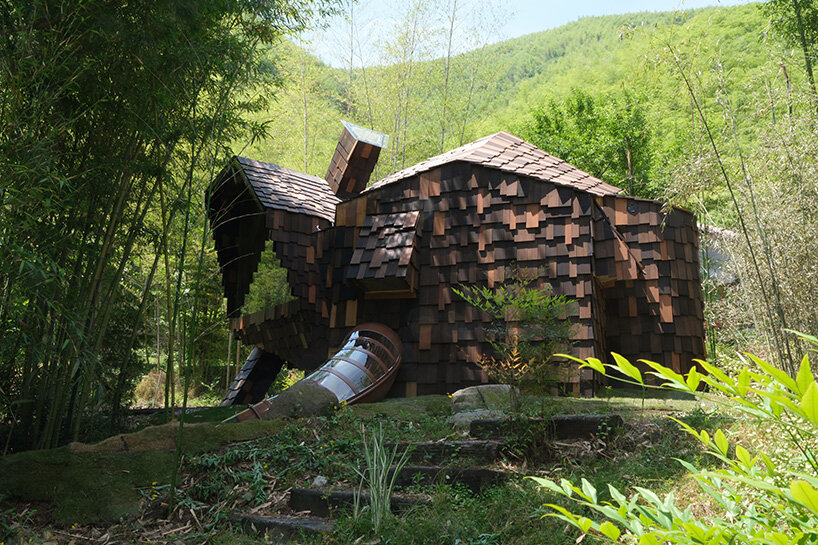 patchwork exterior of 'cat house' in china's anji forest is clad in discarded bamboo tiles