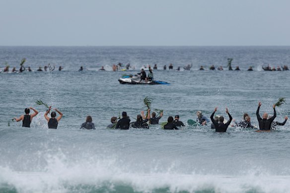Surfers paddle out in memory of shark attack victim Mercury Psillakis in September.