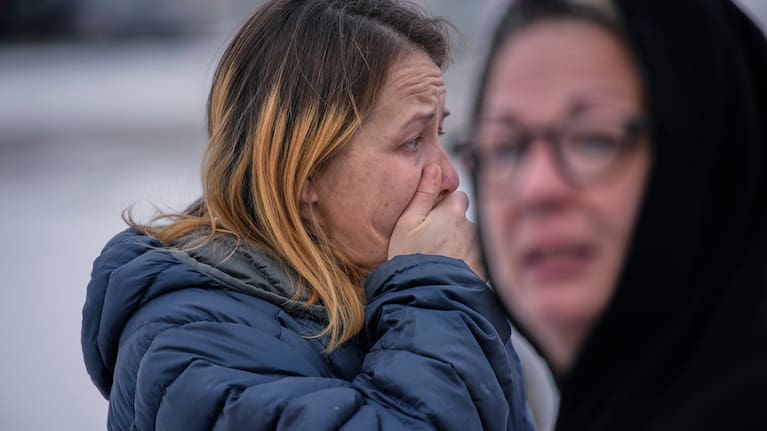 Bystanders react after a man was detained by Immigration and Customs Enforcement (ICE) agents during a traffic stop.