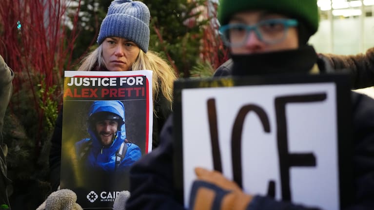 Demonstrator holds signs during a protest outside the office of Senator Amy Klobuchar in Minneapolis, after Alex Pretti was fatally shot by a US Border Patrol officer over the weekend.