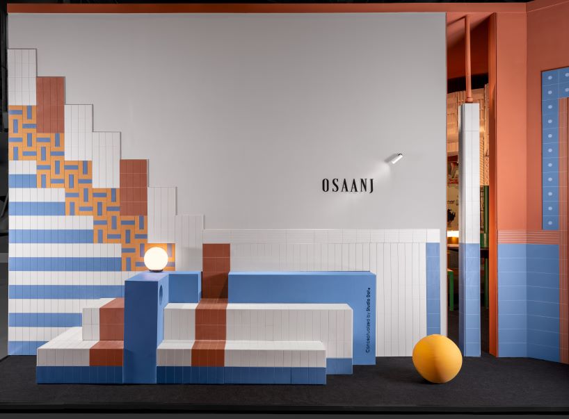 patterned tiles extend from curved walls to furniture in layered retail exhibition booth