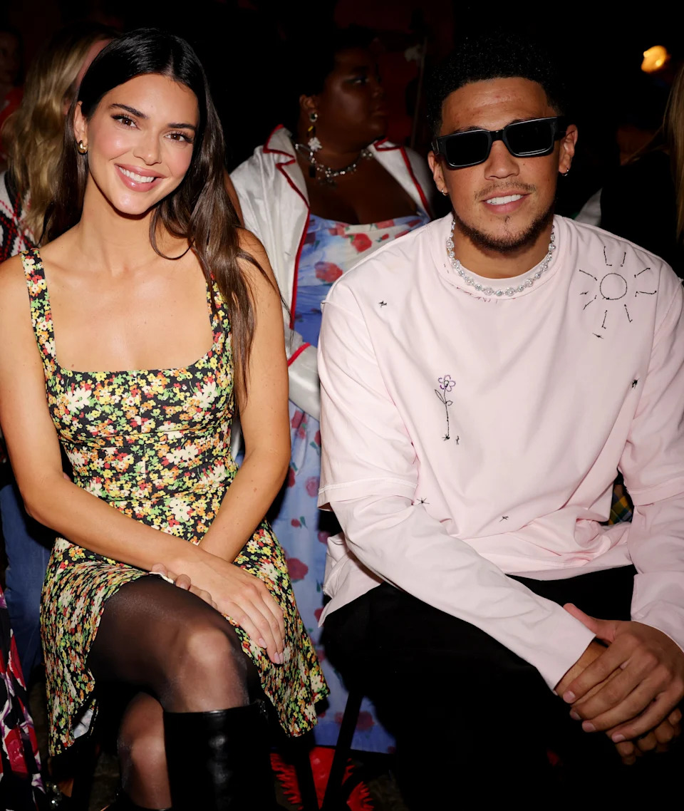 Kendall Jenner and Devin Booker sit together at a fashion event