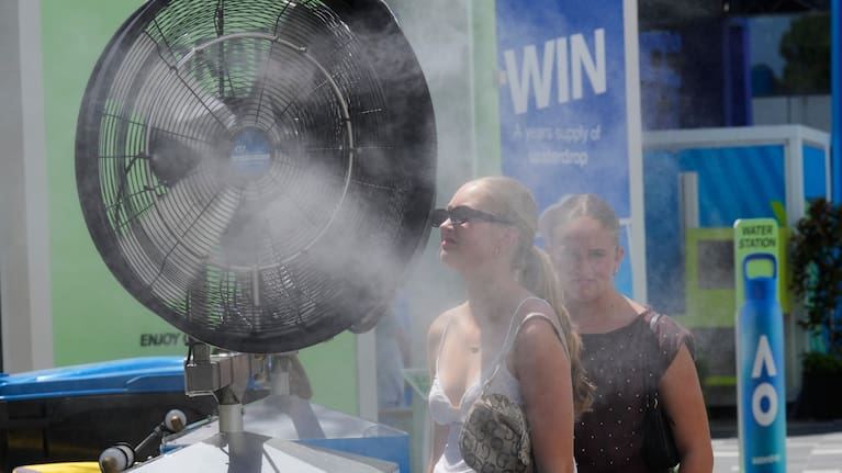 Fans cool down in front of water misters at the Australian Open tennis championship in Melbourne, Australia.