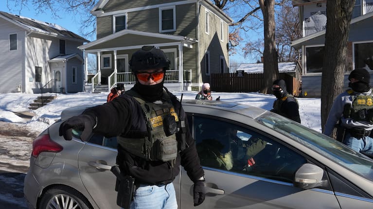 Federal agents approach a vehicle in Minneapolis.