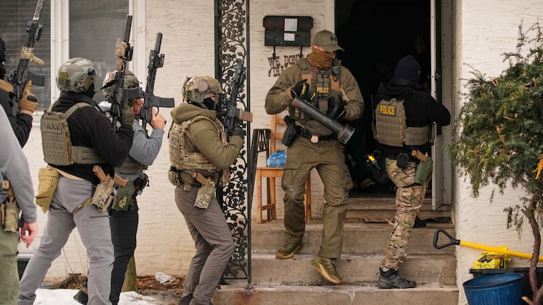 Federal immigration officers prepare to enter a home to make an arrest after an officer used a battering ram to break down a door Sunday, Jan. 11, 2026, in Minneapolis. 
