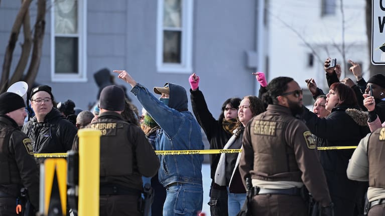 Federal law enforcement officers stand near a roadblock at Portland Avenue and East 32nd Street.