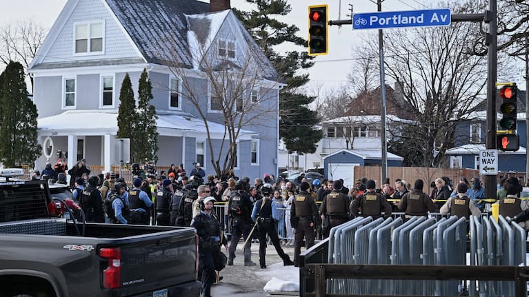 Federal law enforcement officers stand near a roadblock at Portland Avenue and East 32nd Street.