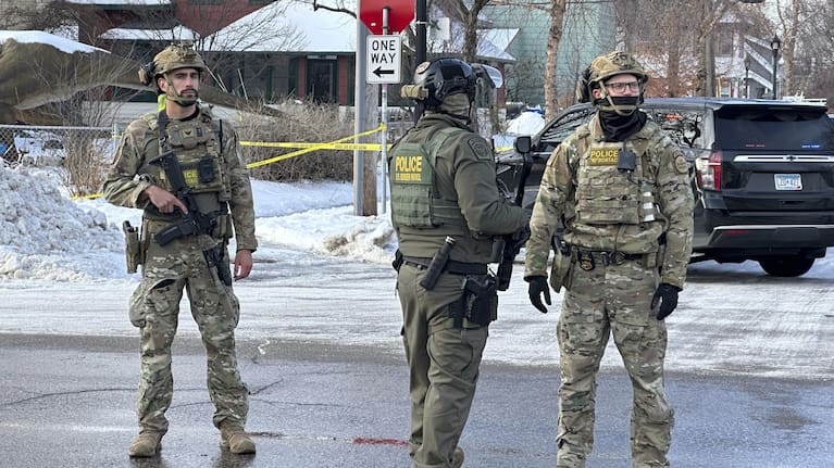 Federal law enforcement officers stand near a roadblock at Portland Avenue and East 32nd Street.