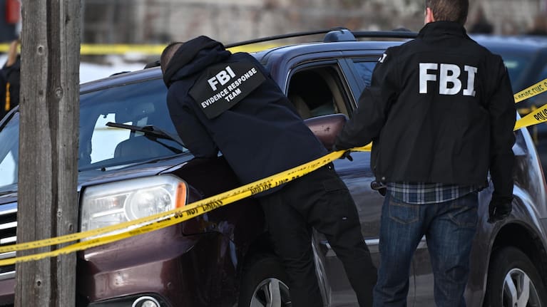 Federal law enforcement officers stand near a roadblock at Portland Avenue and East 32nd Street.