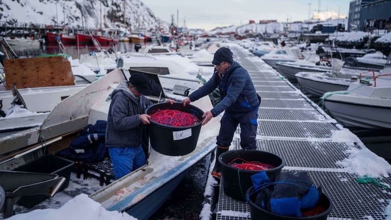 Fishermen load fishing lines into a boat in the harbor of Nuuk, Greenland.