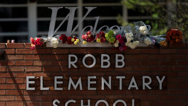 Flowers are placed around a welcome sign outside Robb Elementary School in Uvalde, Texas, May 25, 2022, to honour the victims killed in a shooting at the school. 