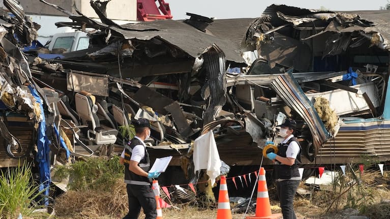 Forensic workers inspect the site of a train accident, a day after a construction crane fell into a passenger train in Nakhon Ratchasima province, Thailand.