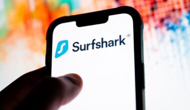 A hand holds a phone with a white screen and Surfshark logo.