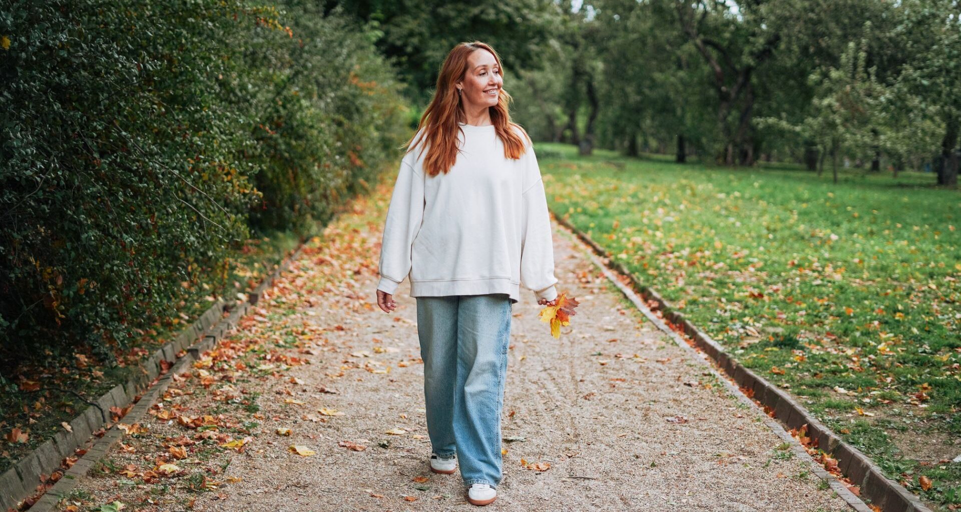 woman walks mindfully in a park in the autumn