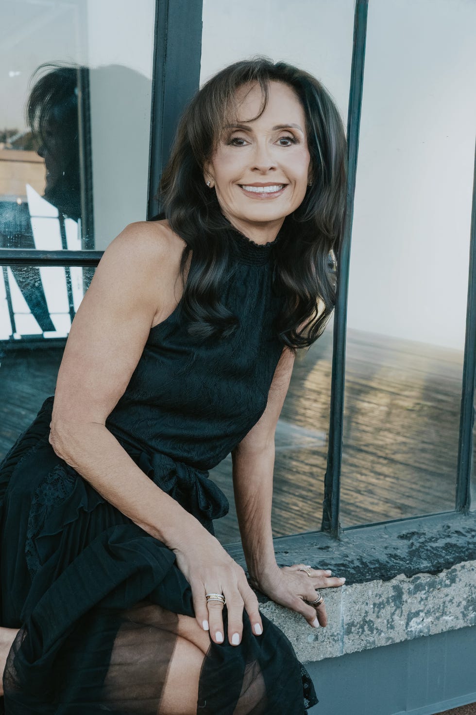 Woman sitting by a window wearing a black outfit woman sitting by a window wearing a black outfit