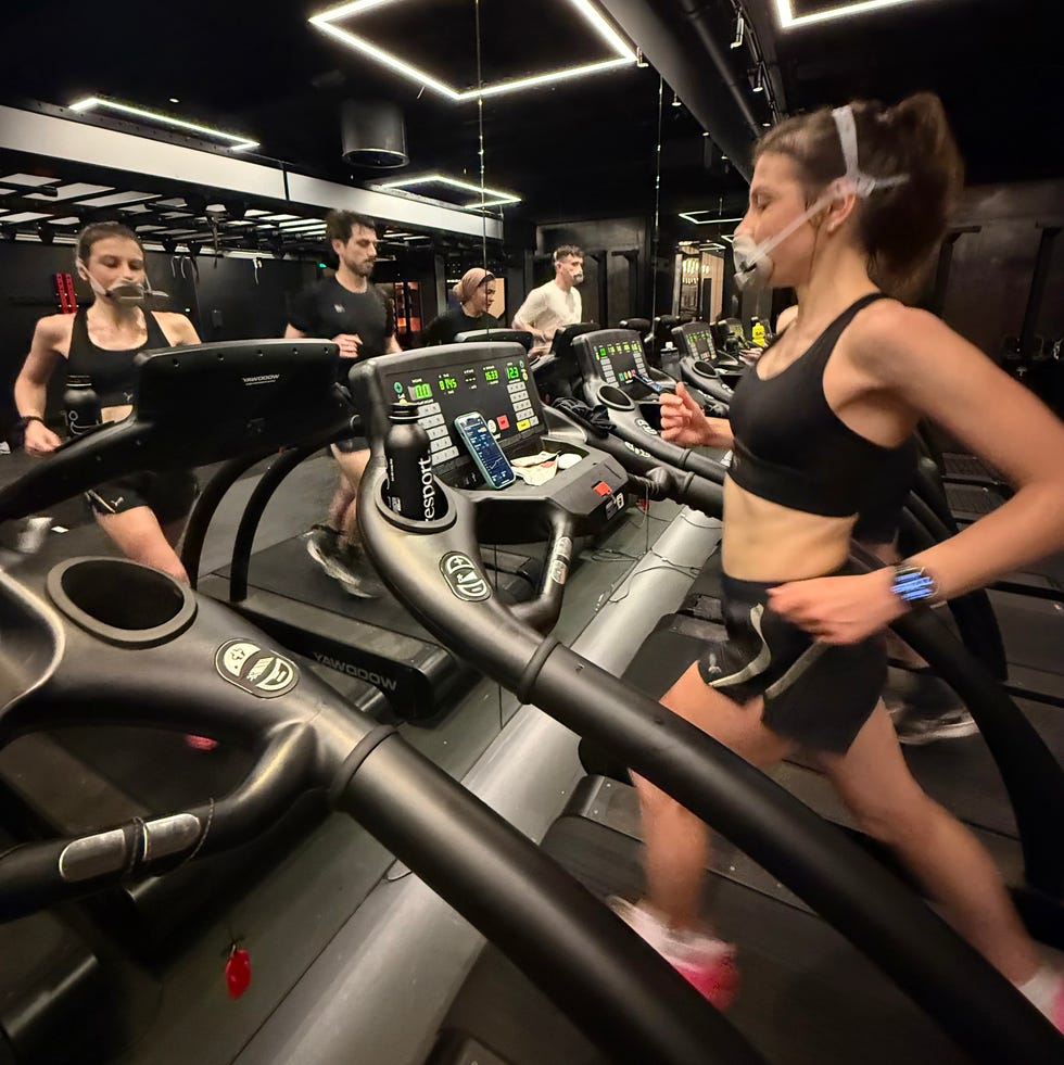 group of individuals exercising on treadmills in a gym