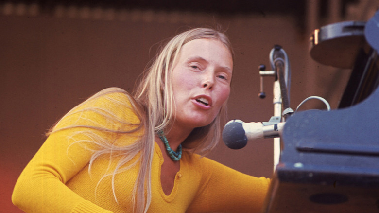 Joni Mitchell on a microphone onstage in the 1970s