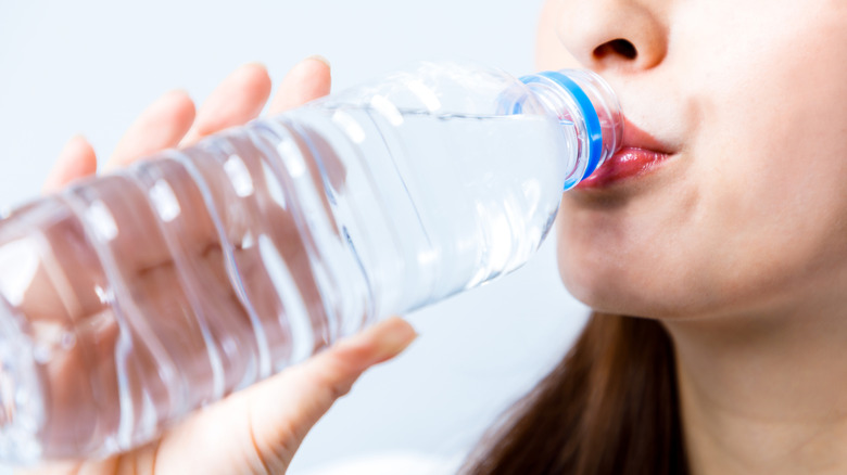 Close-up of a woman drinking from a plastic water bottle