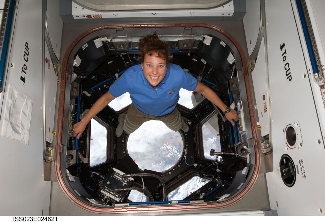 Dottie Metcalf-Lindenburger poses for a photo in the cupola of the International Space Station on April 17, 2010, while space shuttle Discovery remains docked with the station.